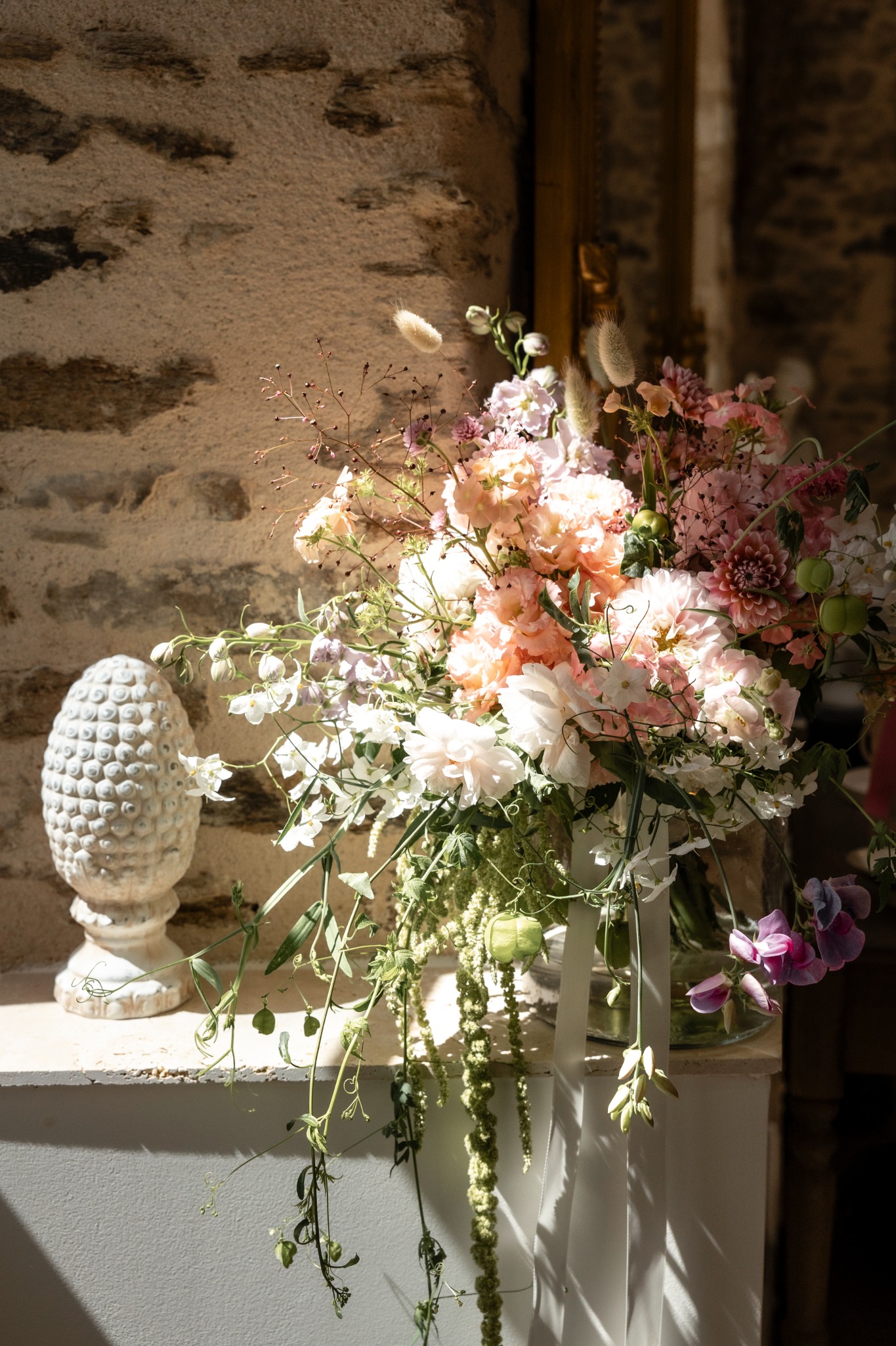 Sunlit wedding flowers inside Château d’Oche
