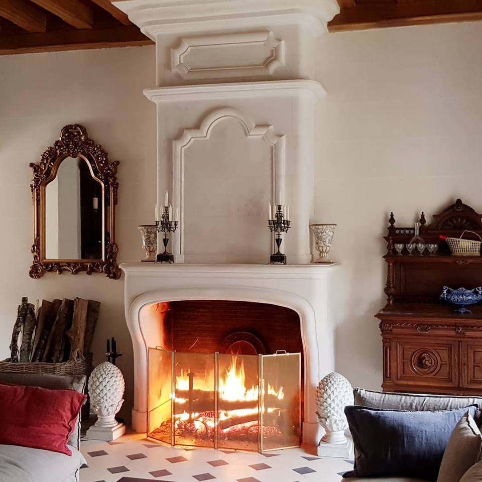 A lit fireplace in one of Château d’Oche's living rooms